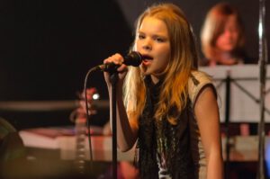 Junge Sängerin am Mikrofon