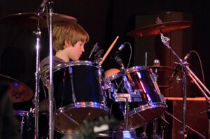 Junger Schlagzeuger auf großer Bühne